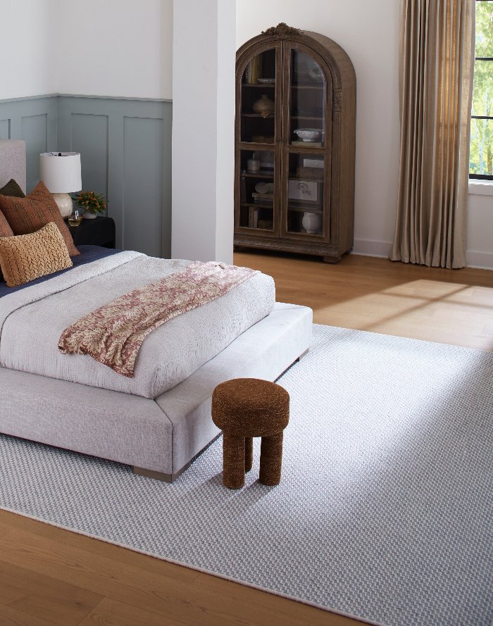 Stylish bedroom with classic hardwood flooring and neutral area rug