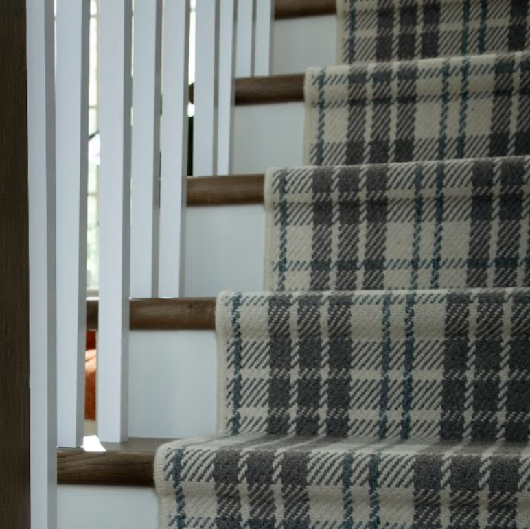 Karastan carpet promotion featuring plaid black and white carpet on stairs in a stylish home